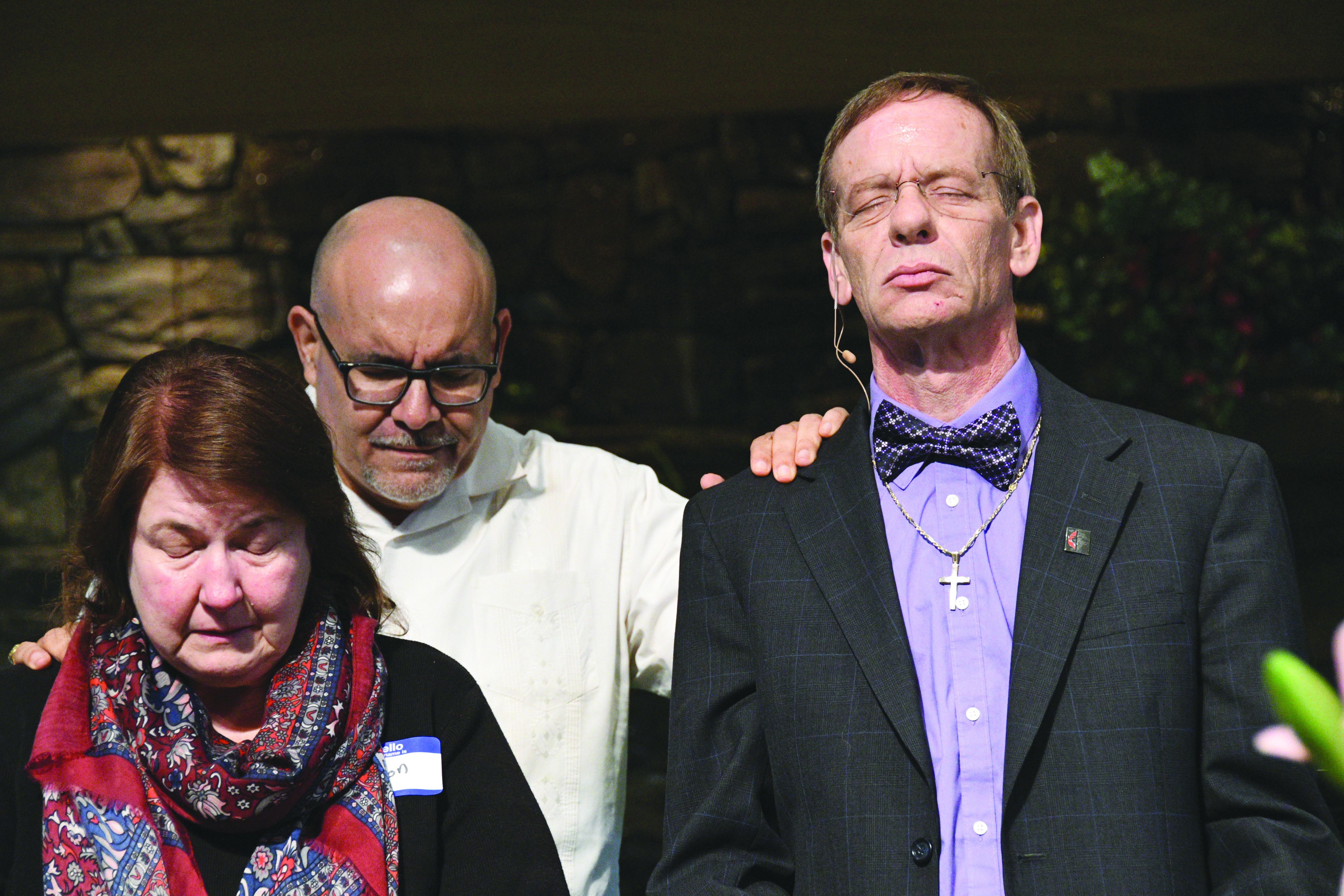 D.S. Edgardo Rivera (center) prays with Sharon Carrigan and Pastor Rick Shuman